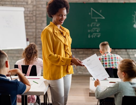 Teacher handing out papers to students